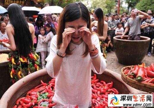 云南丽江宋城旅游区举办吃辣椒比赛 游客泡进辣椒缸吃辣椒