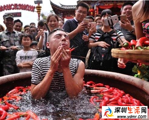 云南丽江宋城旅游区举办吃辣椒比赛 游客泡进辣椒缸吃辣椒